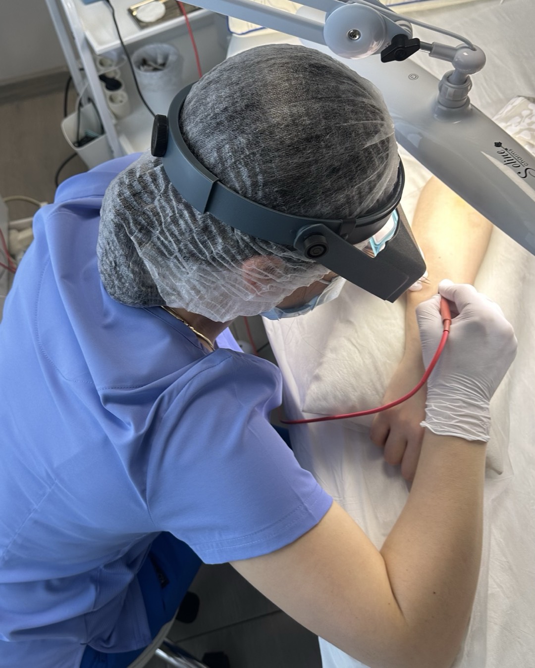 Natalia treating hairs under a magnifying lamp