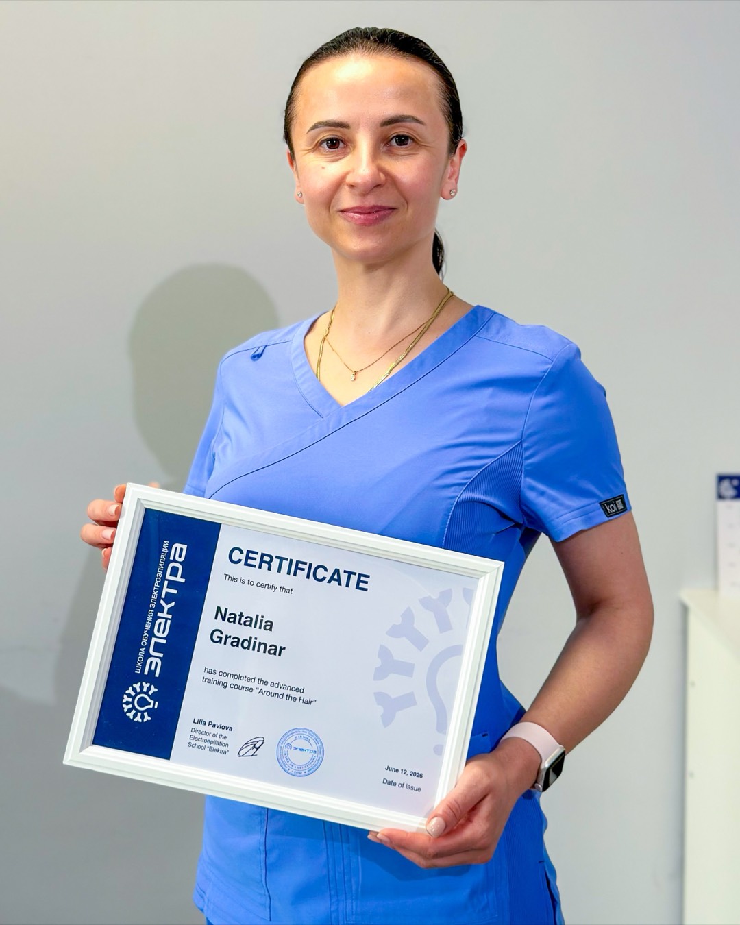Natalia holding her electrolysis training certificate