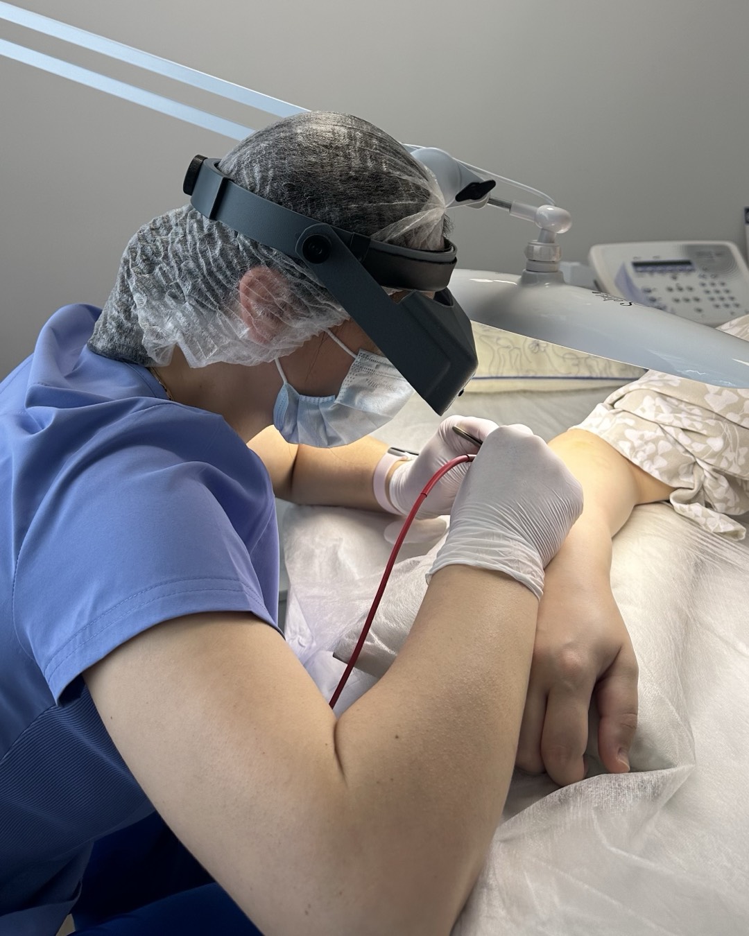 Natalia performing electrolysis on a client's arm